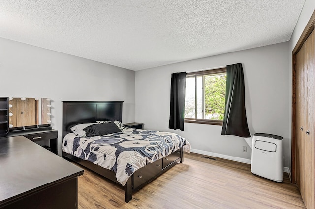 2478 Cobble Hill Alcove Unit C, Woodbury, MN 55125 - bedroom featuring wood finished floors, a textured ceiling, baseboards, and a closet