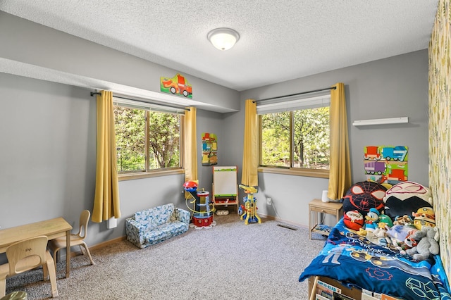 bedroom with carpet flooring, baseboards, and a textured ceiling