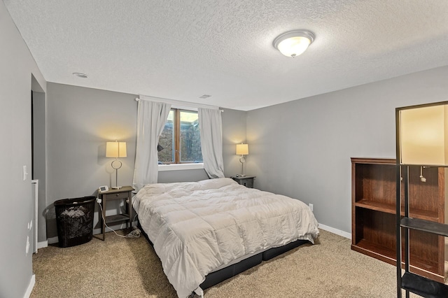 bedroom with a textured ceiling, light colored carpet, and baseboards