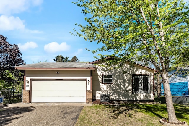 ranch-style home with brick siding, asphalt driveway, and an attached garage