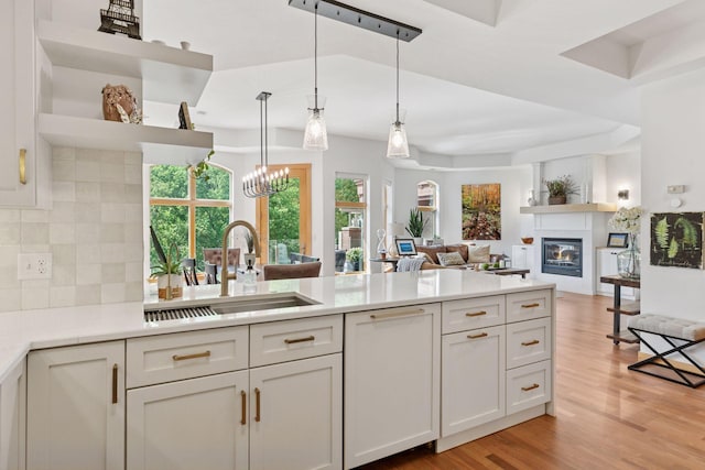 501 Main St N Unit 409, Stillwater, MN 55082 - kitchen with a sink, tasteful backsplash, open shelves, light countertops, and a peninsula