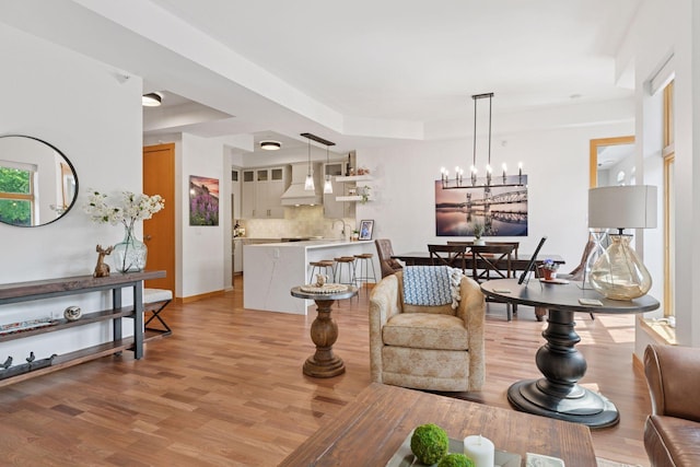 501 Main St N Unit 409, Stillwater, MN 55082 - living area featuring light wood-style floors, a chandelier, a raised ceiling, and baseboards