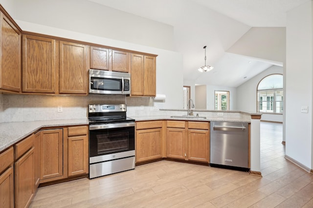 24107 Rivers Edge Rd, Rogers, MN 55374 - kitchen featuring stainless steel appliances, a sink, a peninsula, lofted ceiling, and light wood-style flooring
