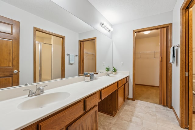 24107 Rivers Edge Rd, Rogers, MN 55374 - full bath featuring double vanity, a walk in closet, a stall shower, and tile patterned flooring