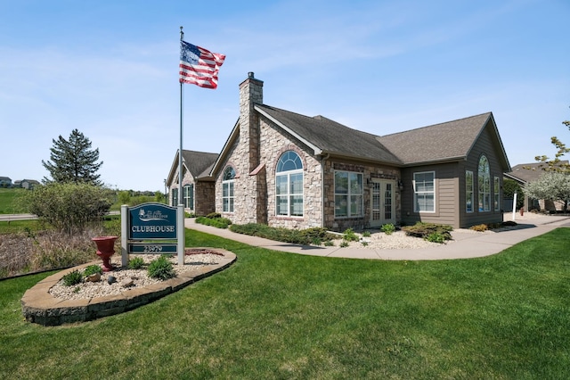24107 Rivers Edge Rd, Rogers, MN 55374 - view of property exterior with stone siding, a chimney, a yard, and a shingled roof