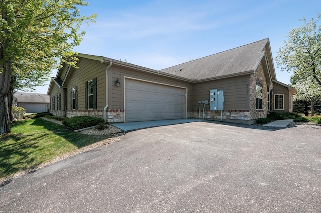 24107 Rivers Edge Rd, Rogers, MN 55374 - view of front of property featuring stone siding, asphalt driveway, a garage, and a front lawn