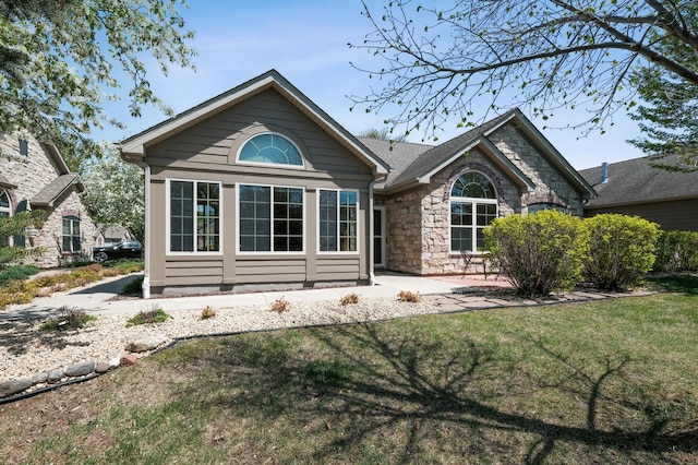 24107 Rivers Edge Rd, Rogers, MN 55374 - rear view of property with stone siding and a lawn