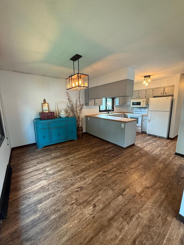 504 Fallwood Rd, Redwood Falls, MN 56283 - kitchen with white appliances, a peninsula, a chandelier, and dark wood-type flooring