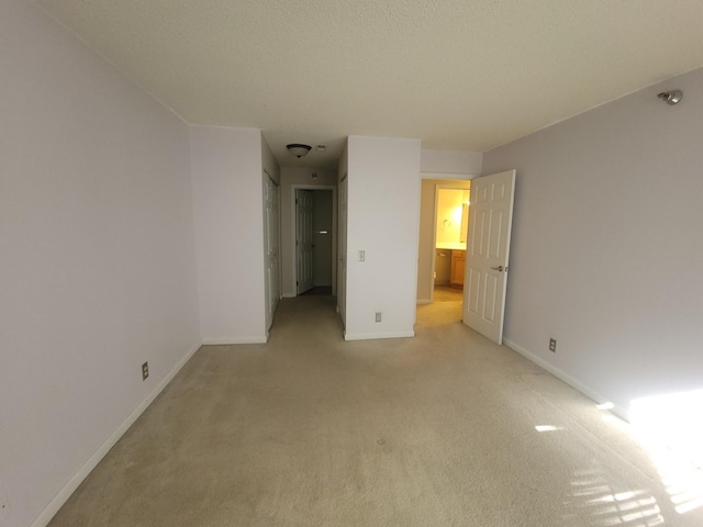 unfurnished bedroom featuring light carpet and baseboards