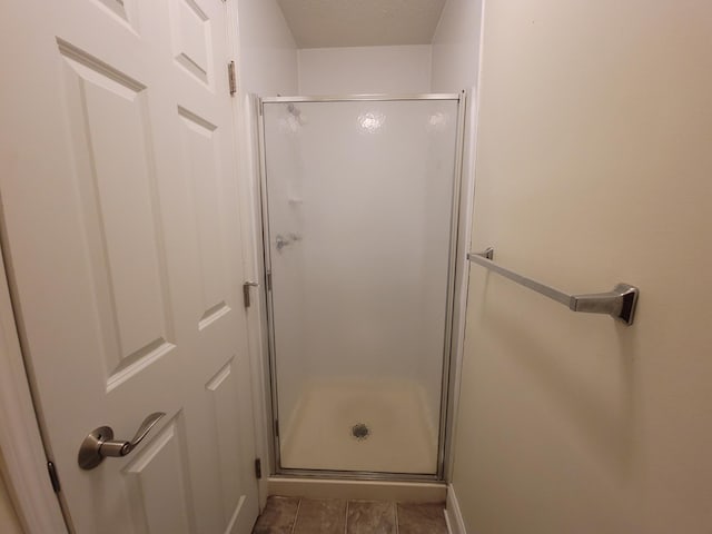 full bath featuring a stall shower and tile patterned flooring