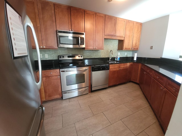 kitchen featuring stainless steel appliances, a sink, decorative backsplash, and light tile patterned floors
