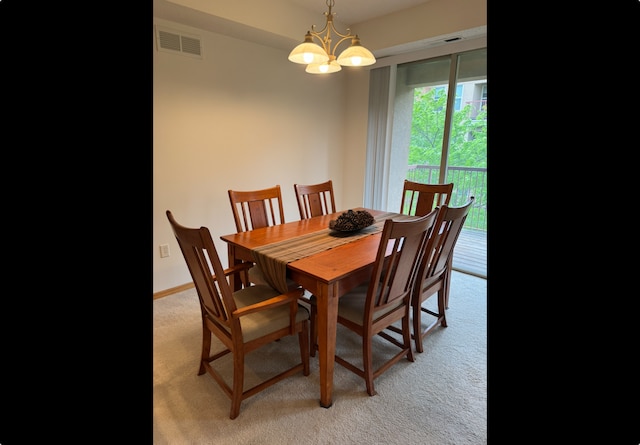 dining area featuring light colored carpet and a chandelier
