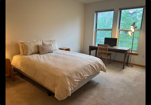 bedroom with carpet floors, baseboards, and an office area