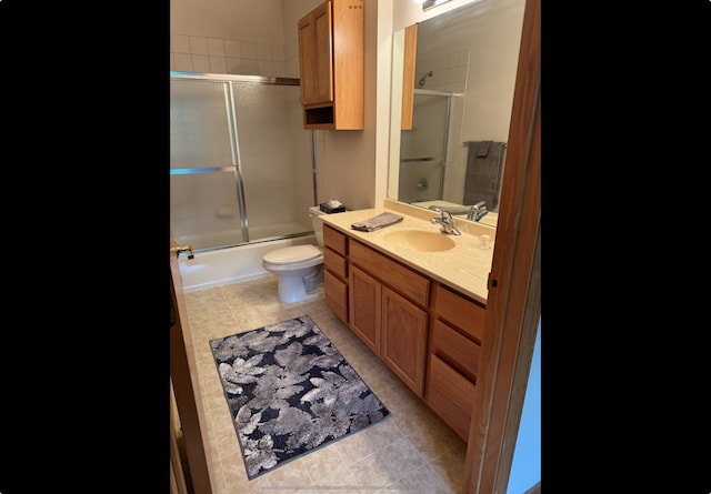 bathroom with vanity, bath / shower combo with glass door, and toilet