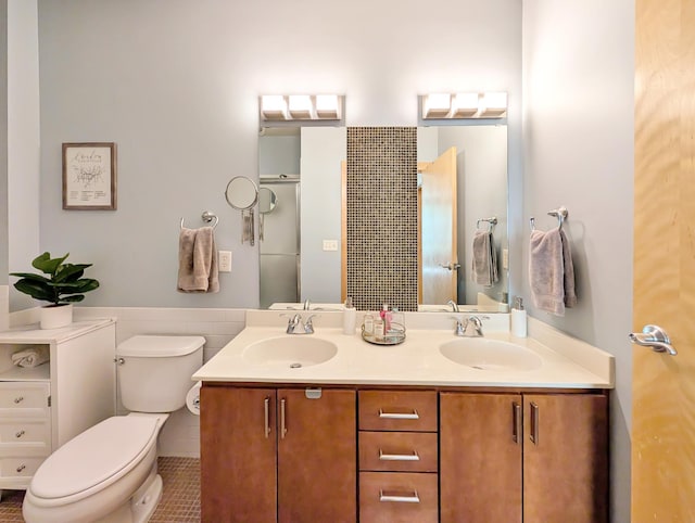 521 2nd St SE Unit 206, Minneapolis, MN 55414 - full bathroom featuring toilet, double vanity, tile patterned floors, and a wainscoted wall
