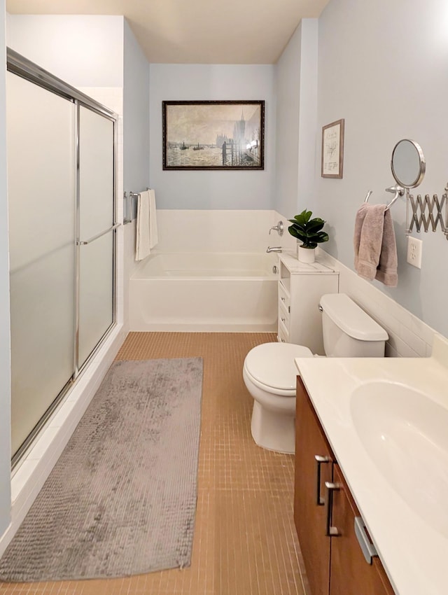 521 2nd St SE Unit 206, Minneapolis, MN 55414 - bathroom featuring a bath, a stall shower, toilet, vanity, and tile patterned floors