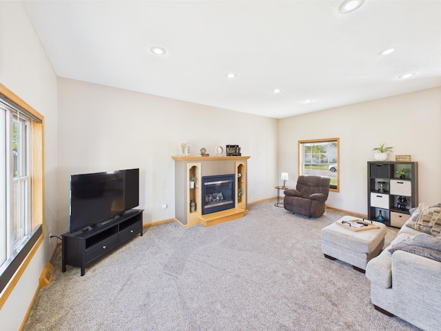 living area with carpet floors, recessed lighting, baseboards, and a glass covered fireplace