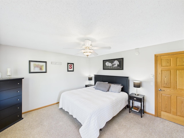 bedroom with light carpet, baseboards, ceiling fan, and a textured ceiling