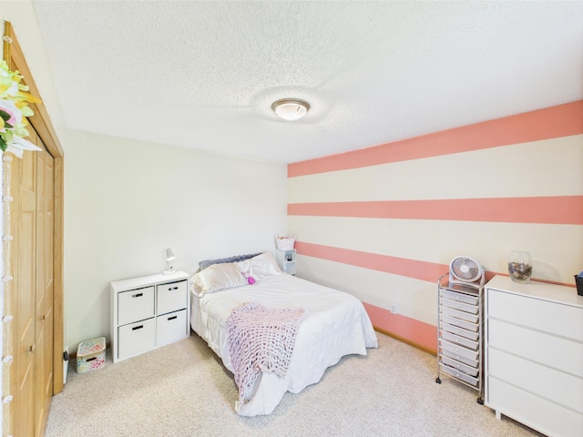 bedroom with light carpet and a textured ceiling