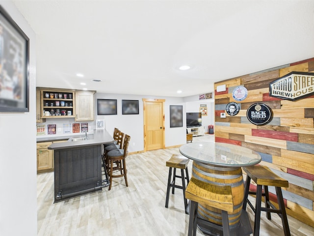 dining area featuring bar, light wood-style floors, recessed lighting, and baseboards
