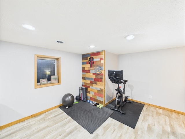 exercise area featuring wood finished floors, baseboards, and recessed lighting