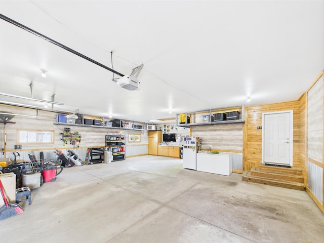 garage featuring wood walls and a garage door opener