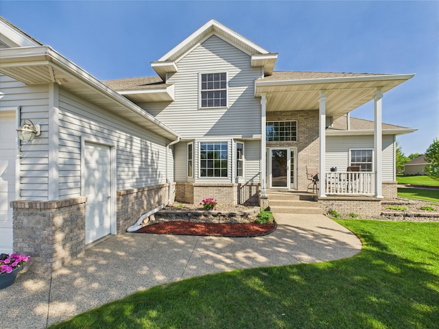 view of front facade with brick siding, a porch, a front lawn, a garage, and a shingled roof