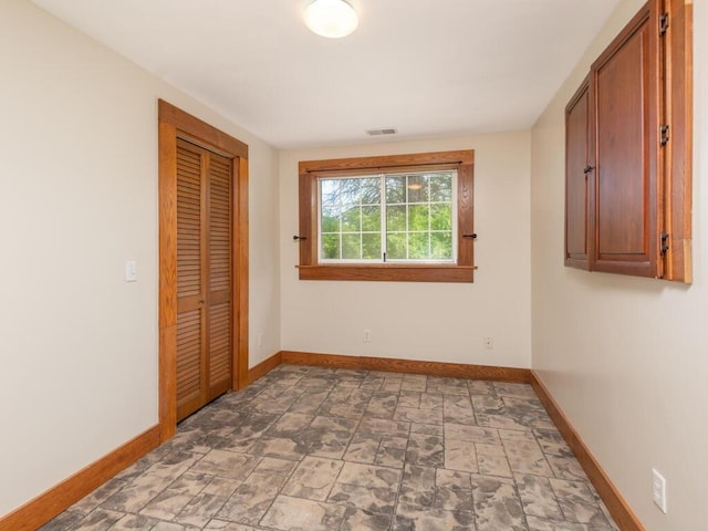 41218 Nelson Rd, North Branch, MN 55056 - unfurnished bedroom with baseboards, light stone finish floors, and a closet