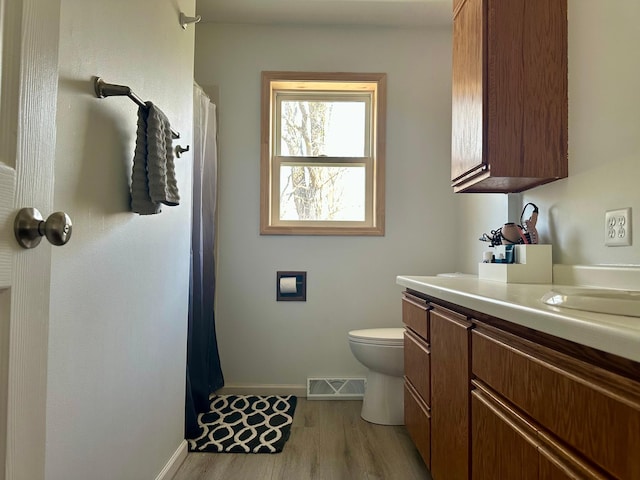 1123 Tyler Ave SE, Bemidji Twp, MN 56601 - bathroom with baseboards, toilet, vanity, wood finished floors, and curtained shower