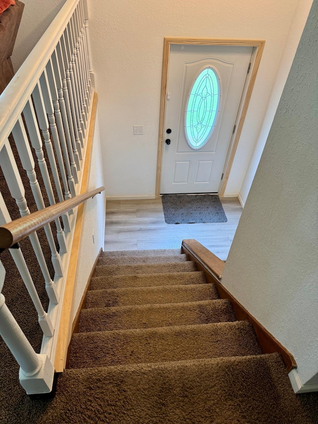 1123 Tyler Ave SE, Bemidji Twp, MN 56601 - stairs featuring wood finished floors, a textured wall, and baseboards