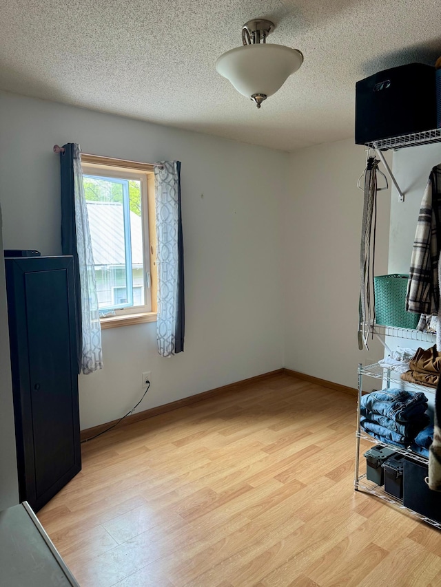 1123 Tyler Ave SE, Bemidji Twp, MN 56601 - unfurnished bedroom featuring light wood-style flooring, a textured ceiling, and baseboards