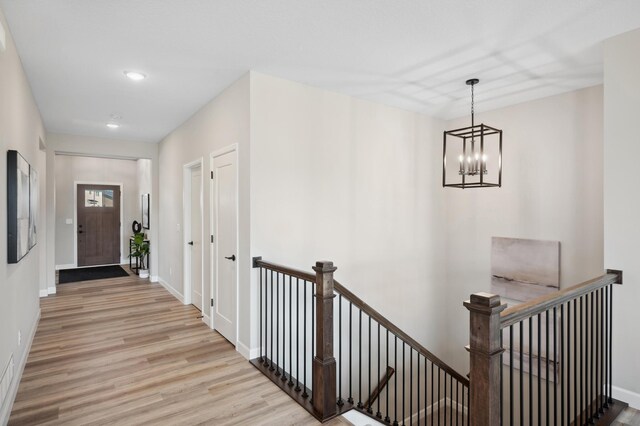 24051 187th St NW, Big Lake, MN 55309 - corridor with an upstairs landing, wood finished floors, a chandelier, baseboards, and recessed lighting
