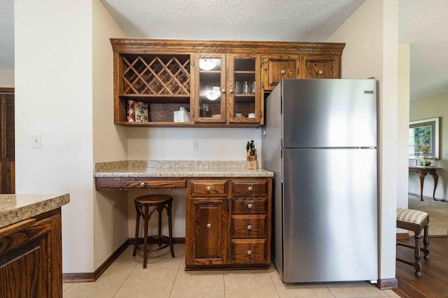 19800 See Gull Rd, Brainerd, MN 56401 - kitchen featuring freestanding refrigerator, a textured ceiling, glass insert cabinets, and open shelves