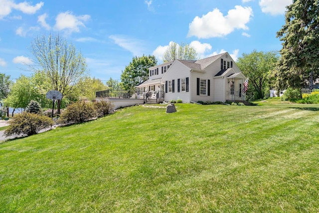 back of property featuring a lawn and a wooden deck