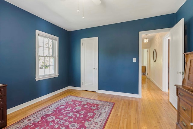 bedroom featuring light wood-style floors, baseboards, and a ceiling fan