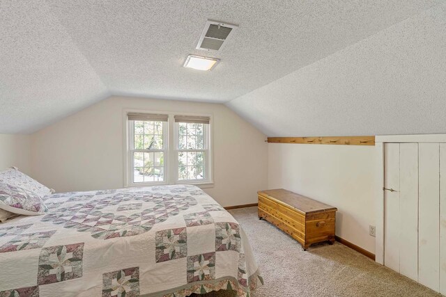 bedroom featuring a textured ceiling, lofted ceiling, light colored carpet, and baseboards