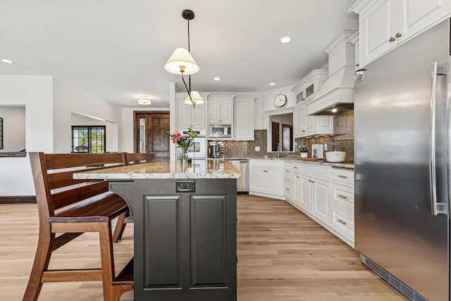 2169 Ibson Ave SE, Rockford Twp, MN 55313 - kitchen featuring built in appliances, light wood-style flooring, white cabinets, a breakfast bar, and recessed lighting