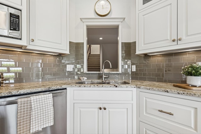 2169 Ibson Ave SE, Rockford Twp, MN 55313 - kitchen with appliances with stainless steel finishes, a sink, white cabinets, tasteful backsplash, and light stone counters