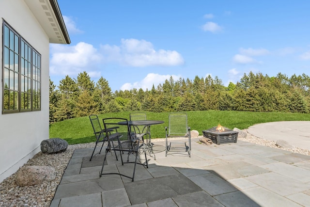 2169 Ibson Ave SE, Rockford Twp, MN 55313 - view of patio / terrace with an outdoor fire pit, outdoor dining space, and a wooded view