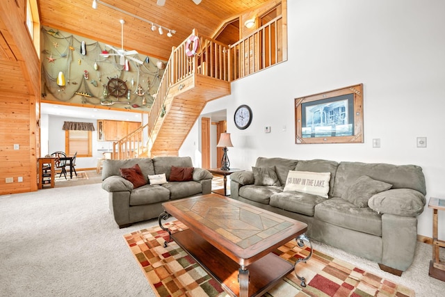21140 654th Ave, Litchfield, MN 55355 - carpeted living area featuring wood ceiling, a towering ceiling, track lighting, stairs, and wooden walls