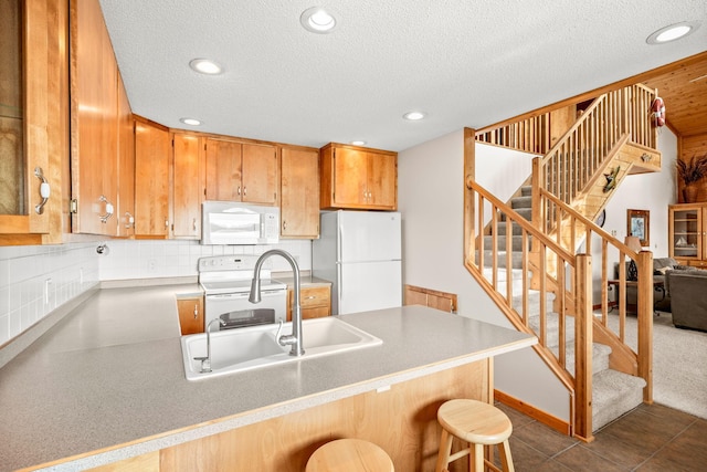 21140 654th Ave, Litchfield, MN 55355 - kitchen with white appliances, recessed lighting, a peninsula, a breakfast bar, and a textured ceiling