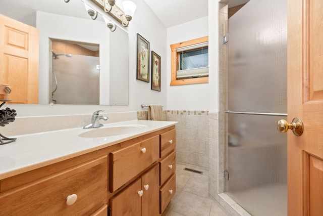 21140 654th Ave, Litchfield, MN 55355 - bathroom featuring vanity, tile patterned flooring, a stall shower, tile walls, and wainscoting
