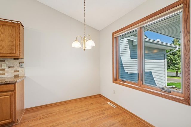 2558 75th St E, Inver Grove Heights, MN 55076 - unfurnished dining area with light wood-type flooring, lofted ceiling, and a chandelier