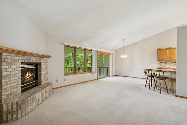 2558 75th St E, Inver Grove Heights, MN 55076 - unfurnished living room with vaulted ceiling, a chandelier, a fireplace, and light colored carpet