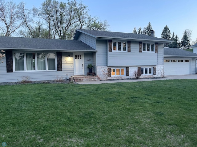 407 2nd Ave W, Lisbon, ND 58054 - split level home with an attached garage, a front lawn, a chimney, and driveway