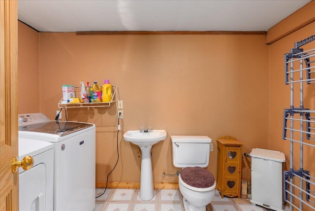1361 60th St Unit D, Apple River Twp, WI 54889 - bathroom featuring washing machine and dryer, toilet, tile patterned floors, and a sink
