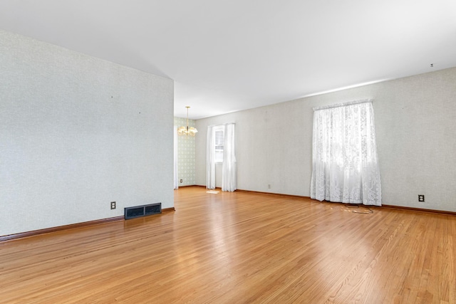 7109 Penn Ave S, Richfield, MN 55423 - unfurnished room featuring a chandelier, light wood-type flooring, and baseboards