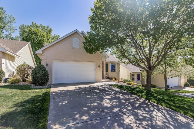 view of front facade with a garage, driveway, stucco siding, and a front yard