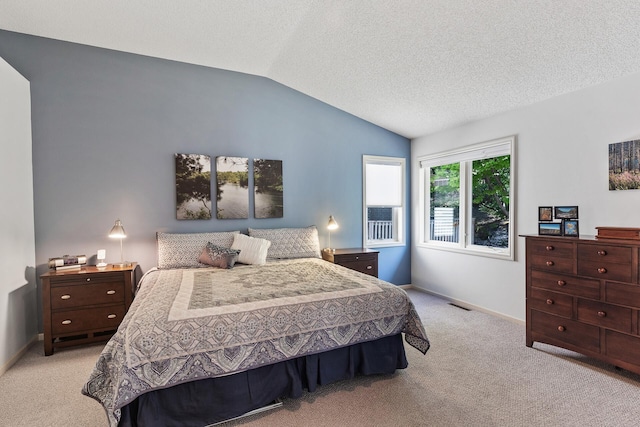 bedroom with carpet floors, vaulted ceiling, baseboards, and a textured ceiling