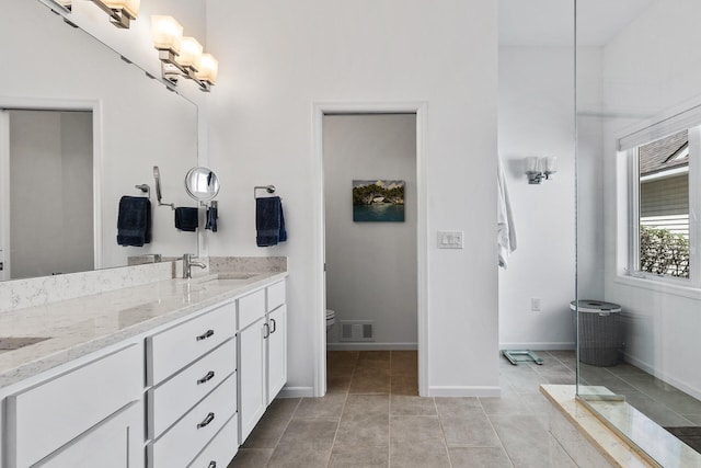 full bathroom with toilet, double vanity, baseboards, and tile patterned floors